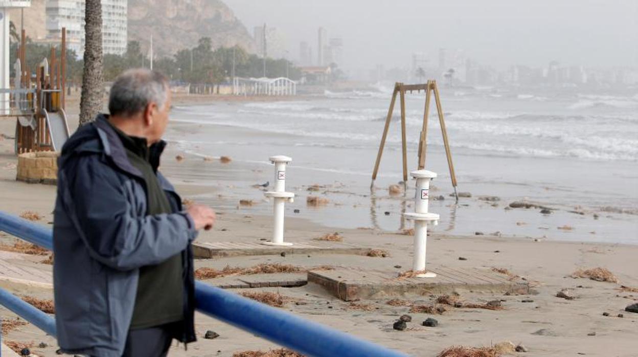 Un hombre observa la playa del Postiguet, este martes cerrada al público