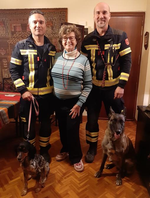 Annie Wellens con los bomberos Rafael Giner y Narciso Ayuso, y las perras Kira y Piba