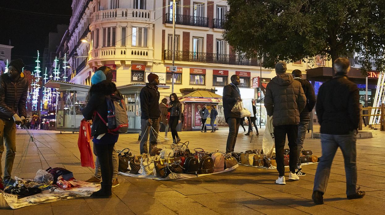 Un grupo de «manteros» vende en la calle productos falsificados