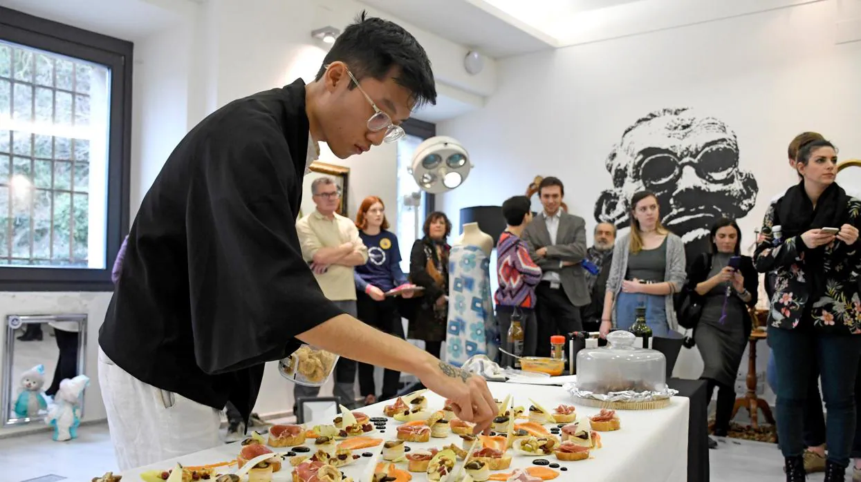 El estudiante de arquitectura chef y pintor vietnamita Xuan Hoang Do durante la construcción de una obra de arte culinario con un lienzo en el Día de la Creatividad