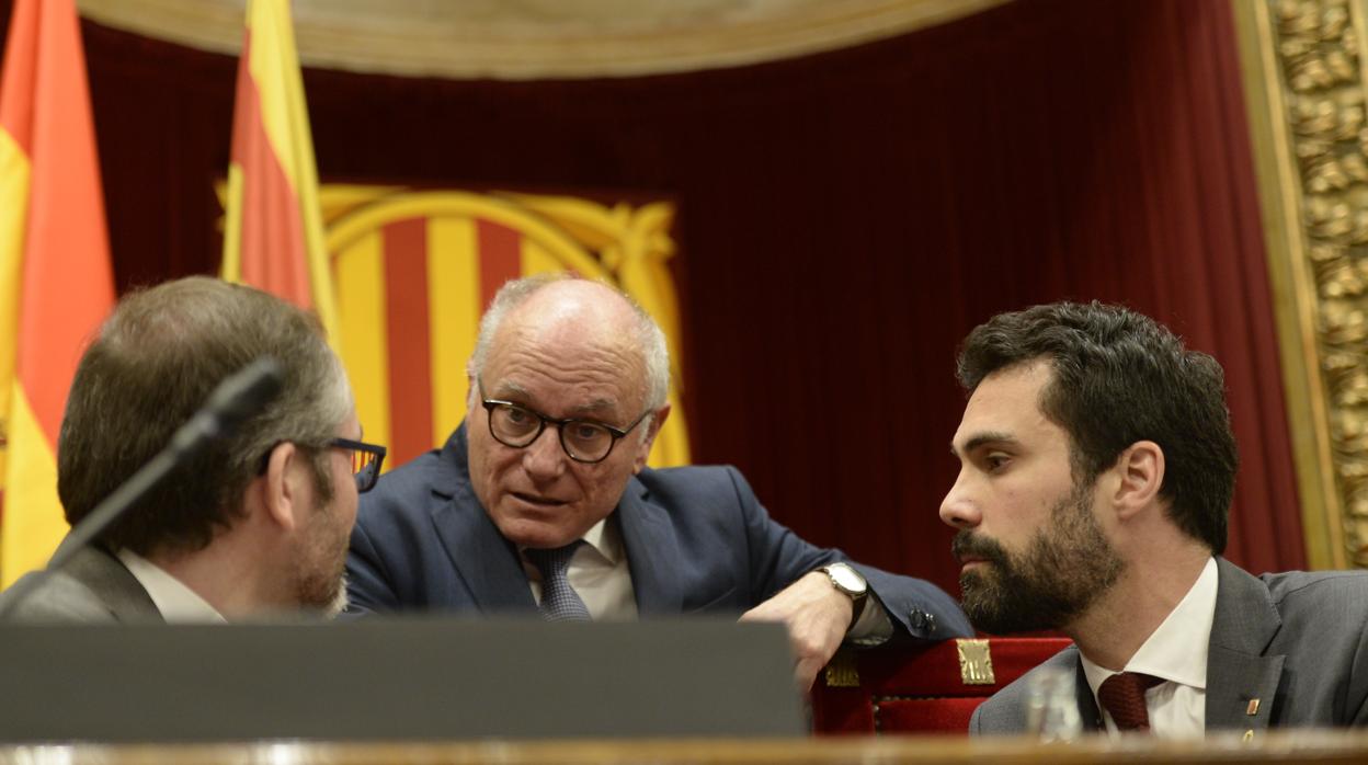 El presidente del Parlament, Roger Torrent, charla con Josep Costa, vicepresidente parlamentario, y el secretario general de la cámara autonómica, Xavier Muro