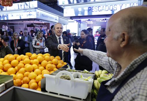 Uno de los vendedores saluda al alcalde, Jorge Azcón, durante la inauguración