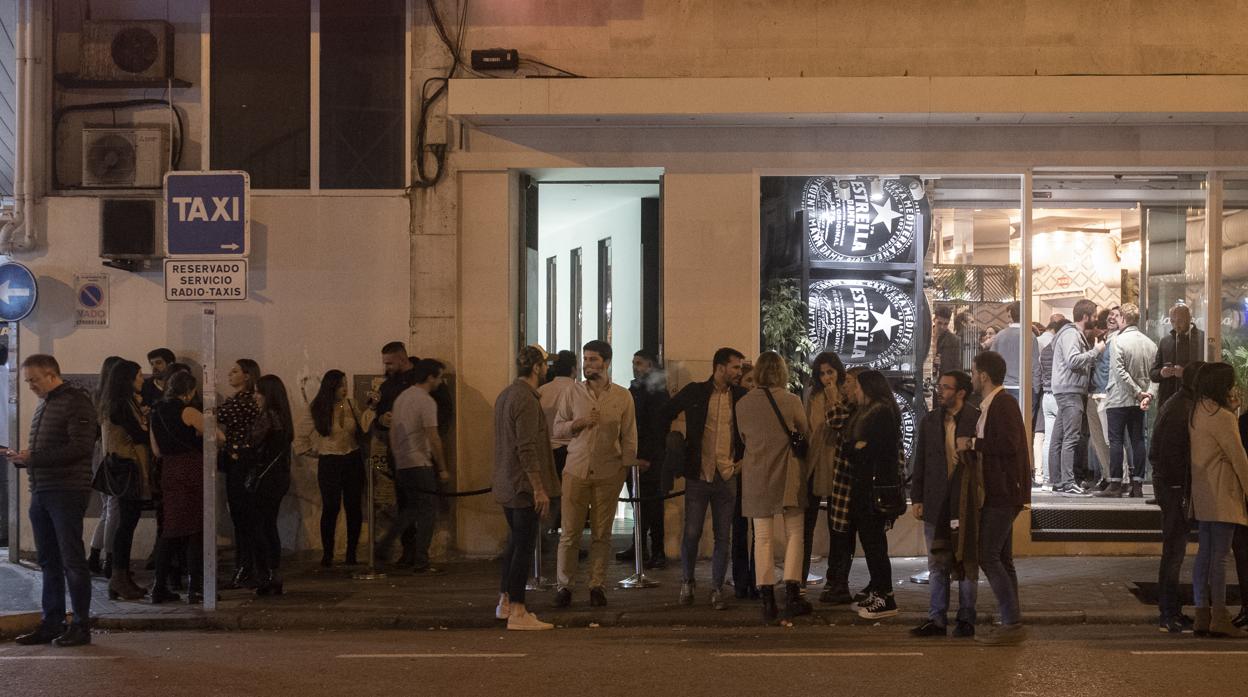 Decenas de personas esperan de noche para entrar en un local, situado en el número 7 de la calle de Ponzano