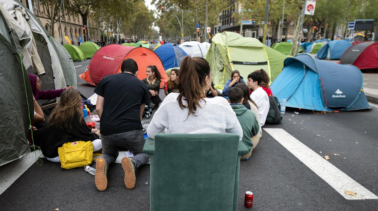 Jóvenes, sentados frente a sus tiendas en la acampada