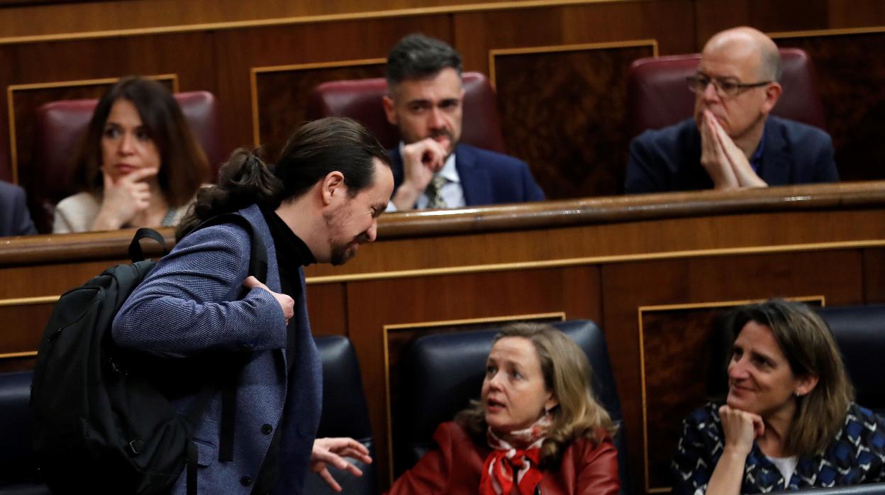 El vicepresidente Pablo Iglesias (i) toma asiento junto a la vicepresidenta de Asuntos Económicos, Nadia Calviño (c) y la vicepresidenta y ministra para la Transición Ecológica, Teresa Ribera