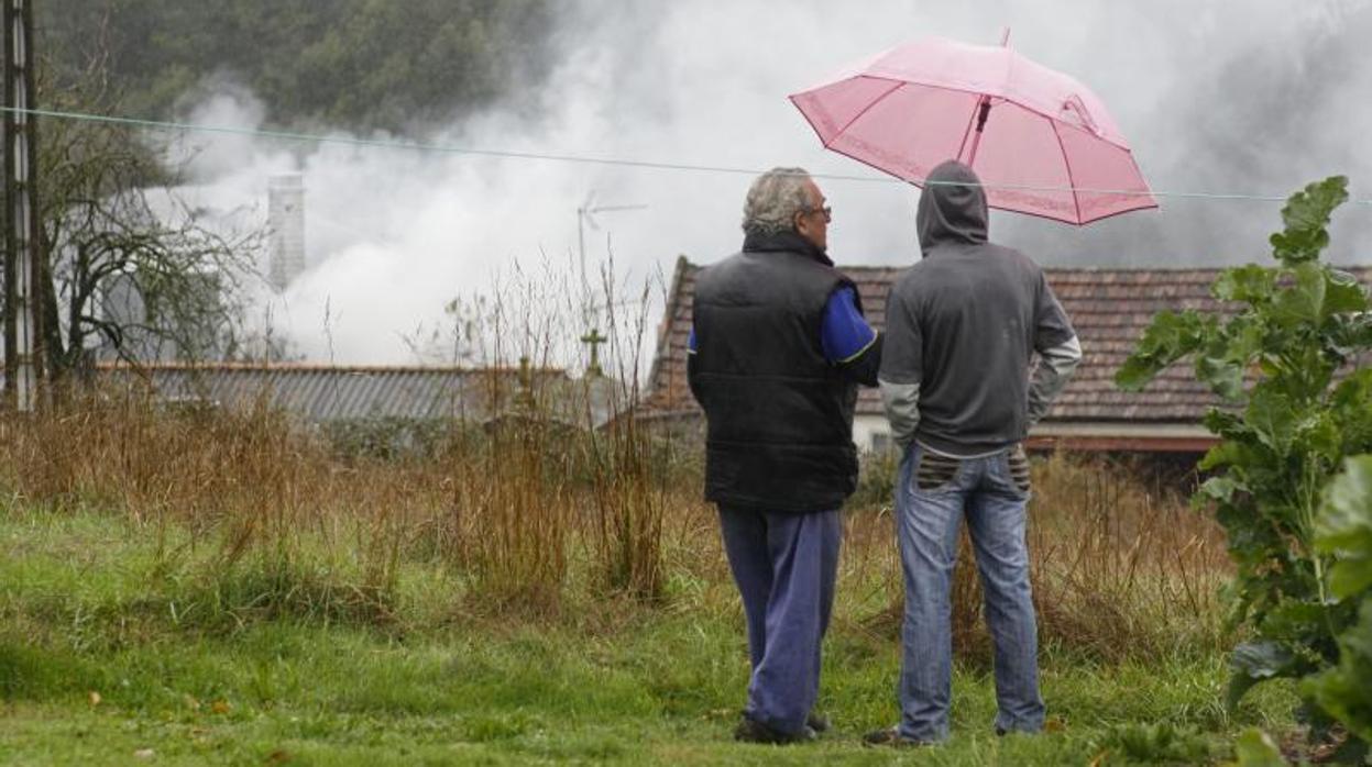 Dos personas observan un incendio en el municipio de Lalín en una imagen de archivo