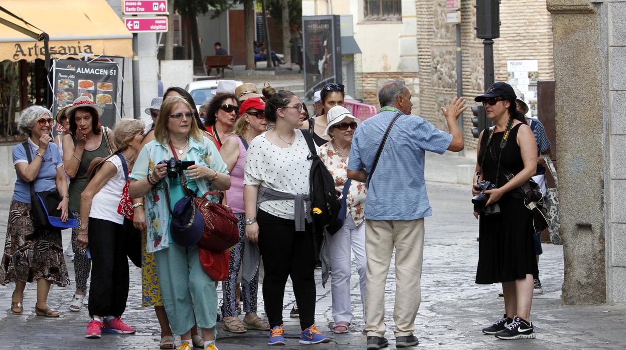 Un grupo de turistas atiende a las indicaciones de un guía turístico