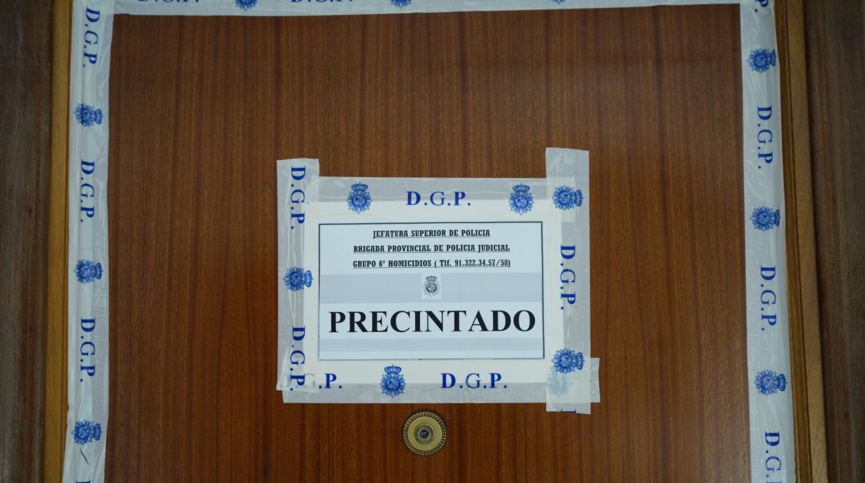 Puerta precintada por la Policía Nacional de la vivienda donde ocurrió el crimen, en San Blas