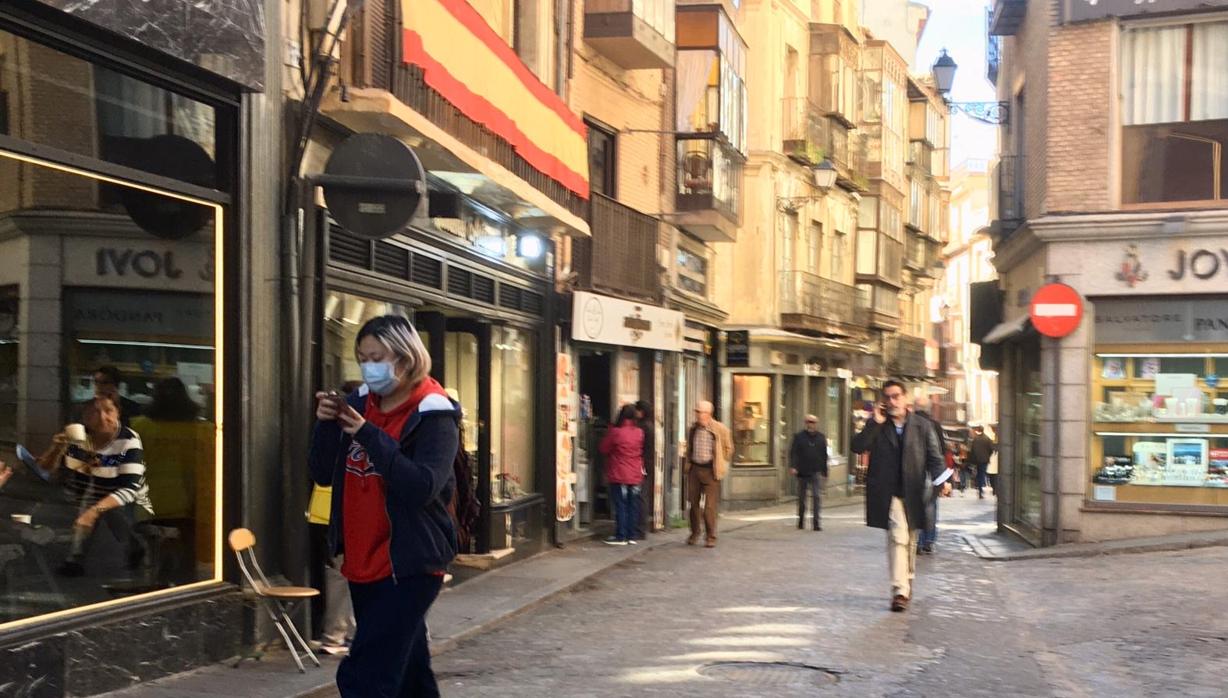 Una mujer con una mascarilla en la calle Comercio