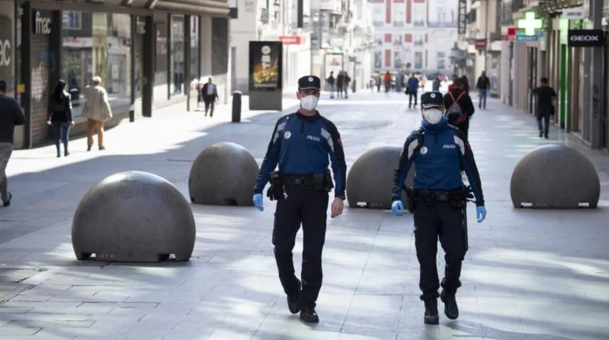 Dos policías municipales patrullan ayer por una casi desierta calle Preciados de Madrid con mascarilla por la crisis del coronavirus