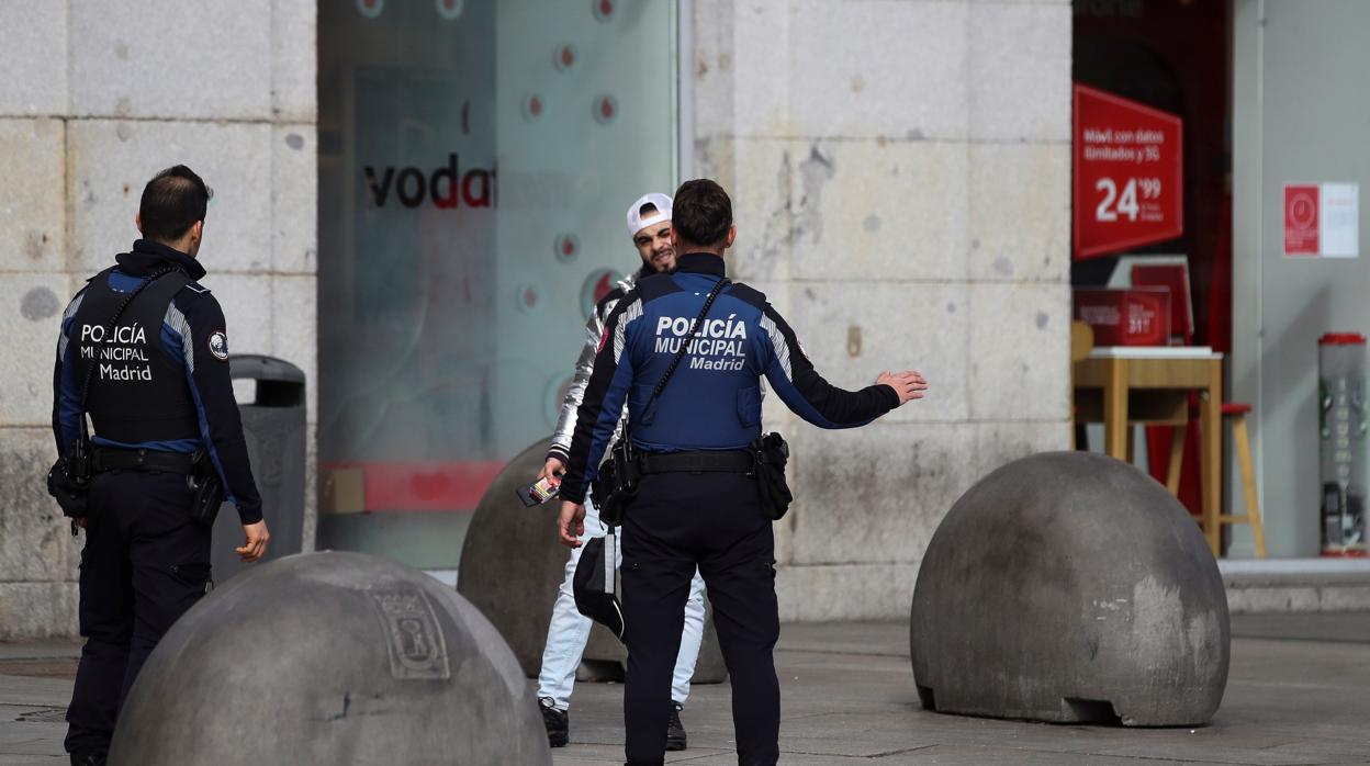 La Policía Municipal para, ayer, a un viandante en la Puerta del Sol para informarle sobre el Covid-19