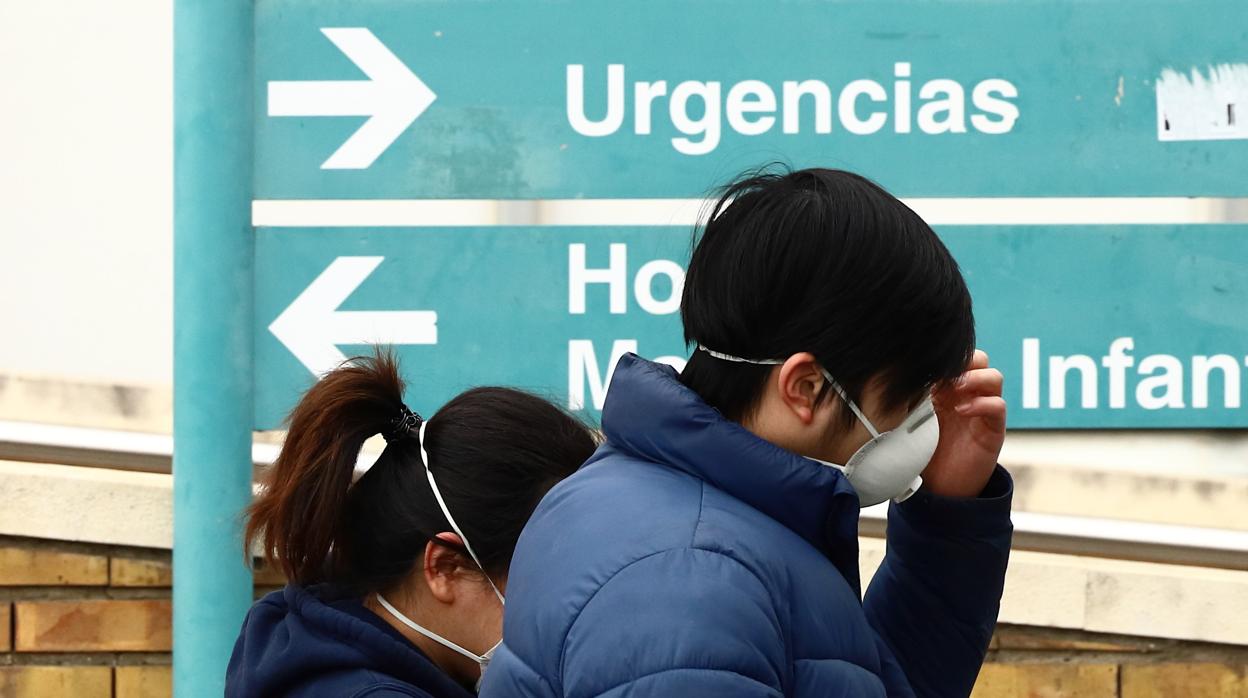 Dos personas pasan ante un hospital en Zaragoza