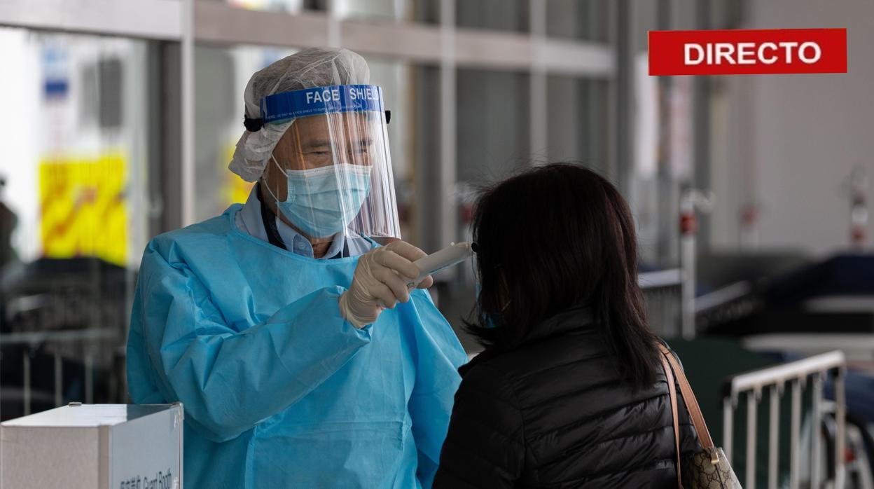 Un sanitario toma la temperatura a una mujer