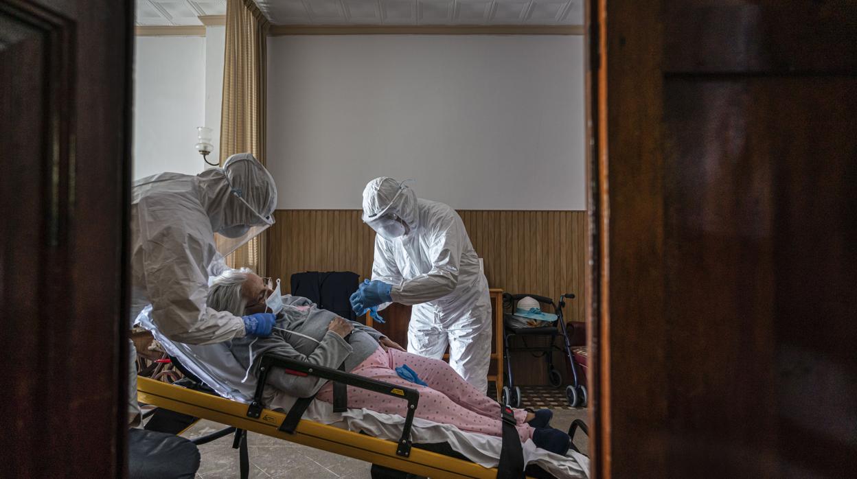 Retrato del traslado de una contagiada de coronavirus desde su casa a un hospital