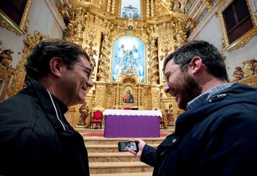 Salvador Jesús Corbí (izquierda), parroco de la iglesia de de La Asunción de la localidad valenciana de Torrent,bromea con Jordi, su vicario, mientras ven el teléfono móvil alguna de las misas