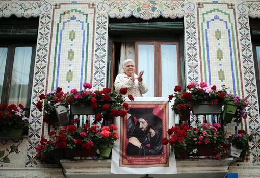 Una vecina del barrio del Cabañal aplaude a los sanitarios desde su balcón engalanado con motivos religiosos