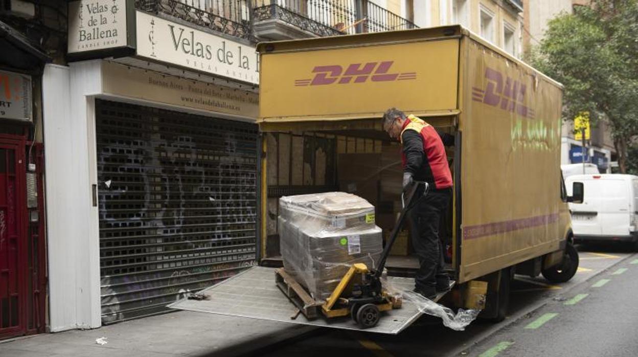 Un transportista baja un palé con mercancía de un camión