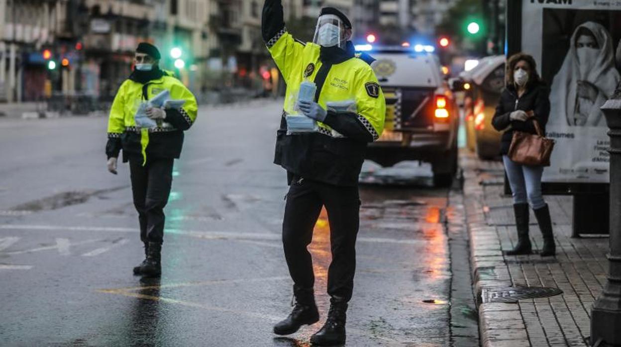 Agentes de la Policía Local reparten mascarillas, este miércoles en Valencia