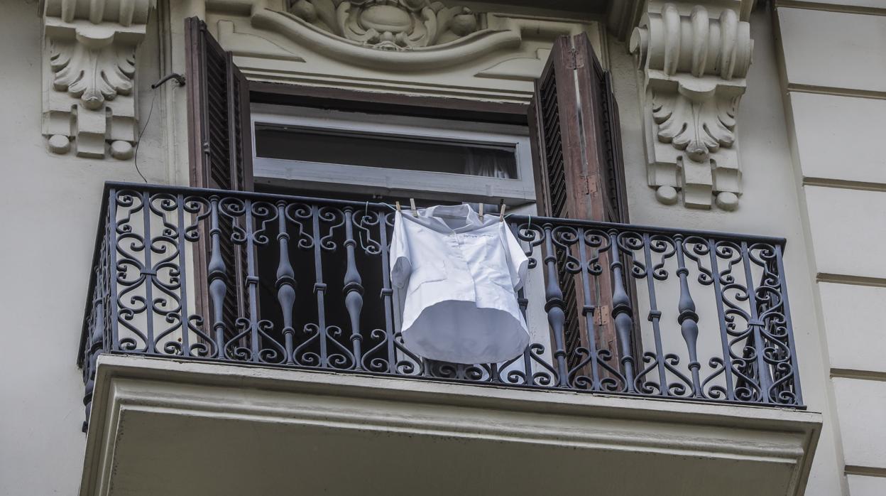 Una bata sanitaria cuelga de un balcón de Valencia