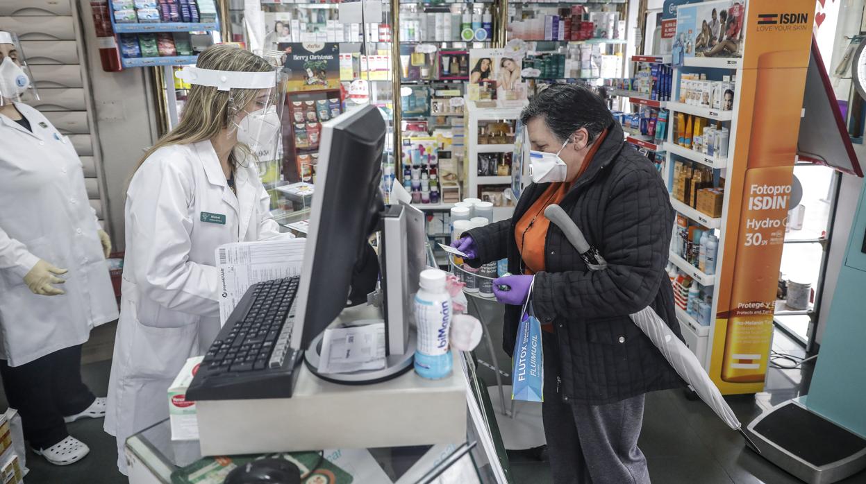 Una farmacia dispensa mascarillas a una clienta este martes