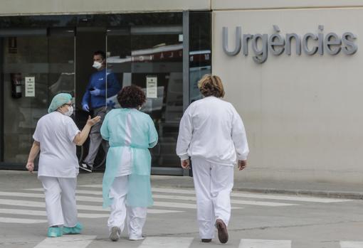 Sanitarios con mascarilla en la puerta de Urgencias de un hospital