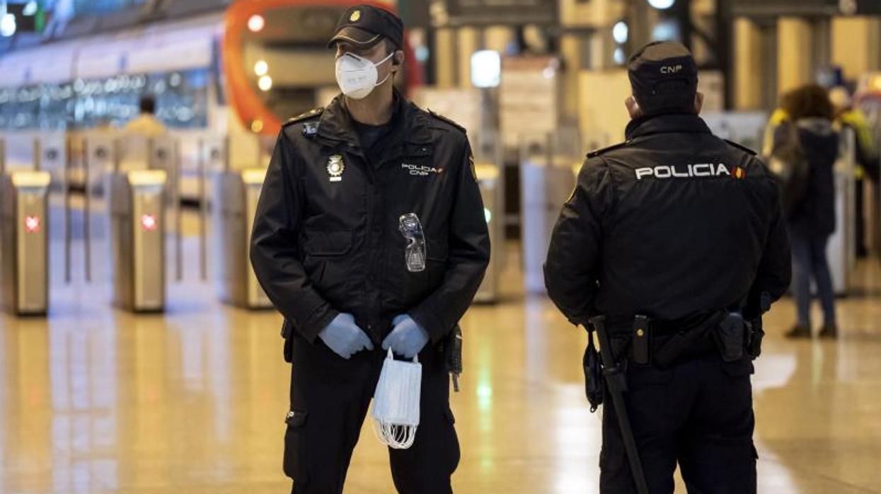 Dos policías nacionales reparten mascarillas en Valencia durante el estado de alarma