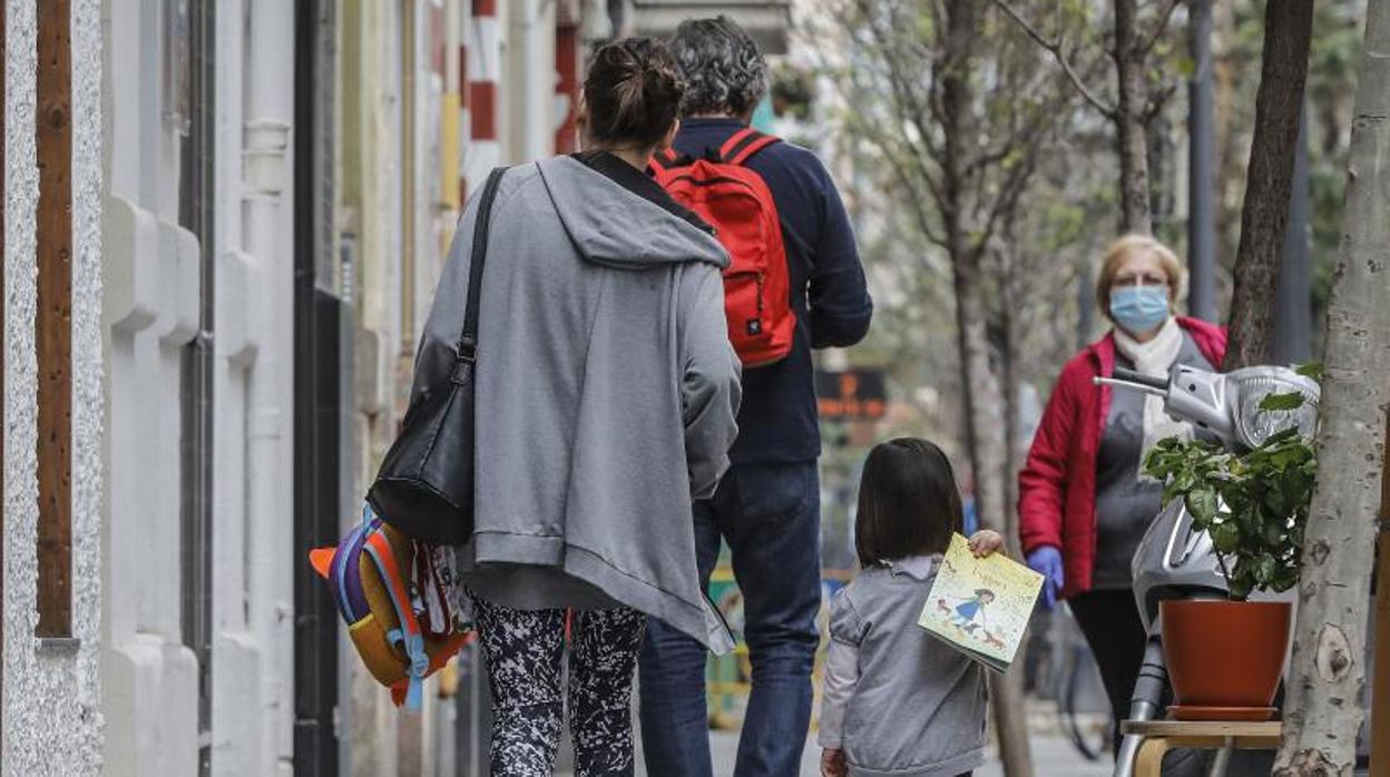 Una familia camina por una calle de Valencia durante el estado de alarma