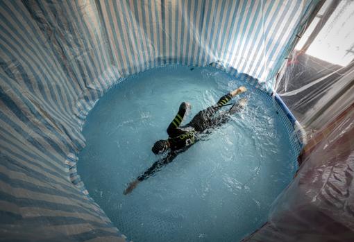 Héctor entrena en una piscina desmontable atado a la cintura con una cuerda