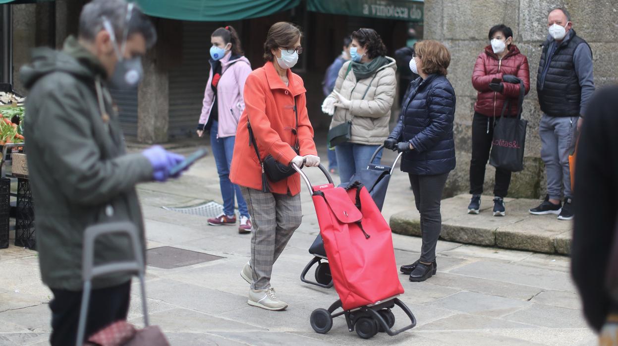 Varias personas hacen compra en el Mercado de Abastos de Santiago este domingo