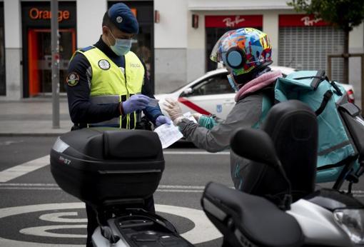 Un agente comprueba la documentación de un repartidor de comida en la Gran Vía