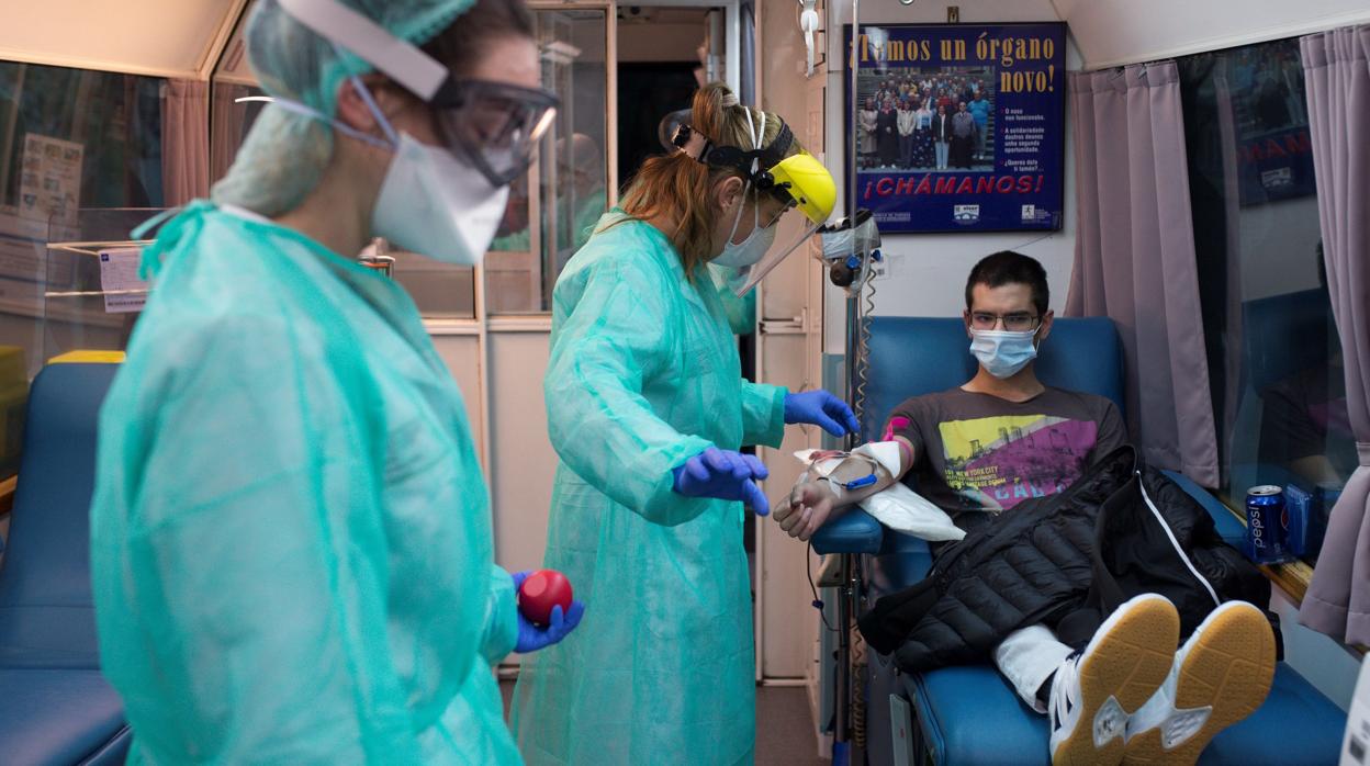 Una trabajadora sanitaria extrae la sangre a un donante en el interior del autobús de la Axencia de Doazón de Órganos e Sangue (ADOS)