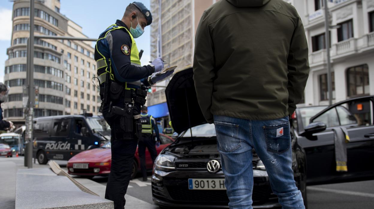 Un agente de la Policía Municipal multa a una persona que incumplió el estado de alarma