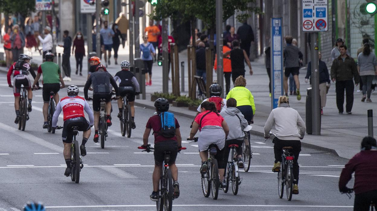 Decenas de personas pasean y montan en bicicleta por una calle de Madrid