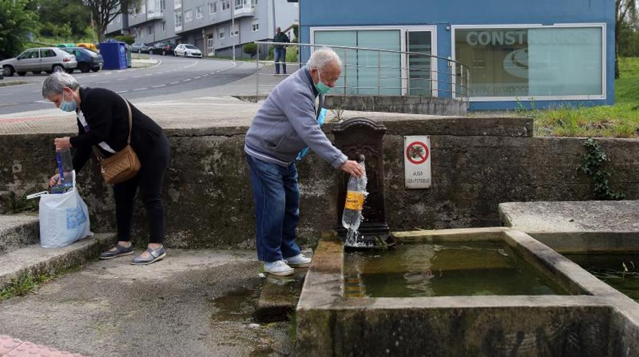 Dos personas hacen acopio de agua en Santiago