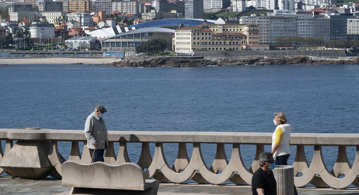 Dos personas caminan por el paseo marítimo de La Coruña el domingo