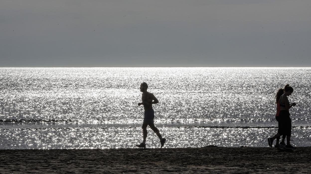 Imagen de un hombre practicando deporte en una playa de Valencia