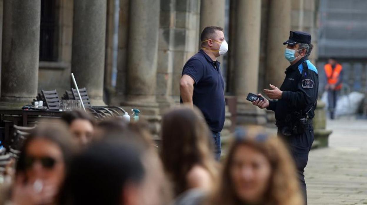 Un agente de Policía dialoga con el propietario de un local el pasado lunes