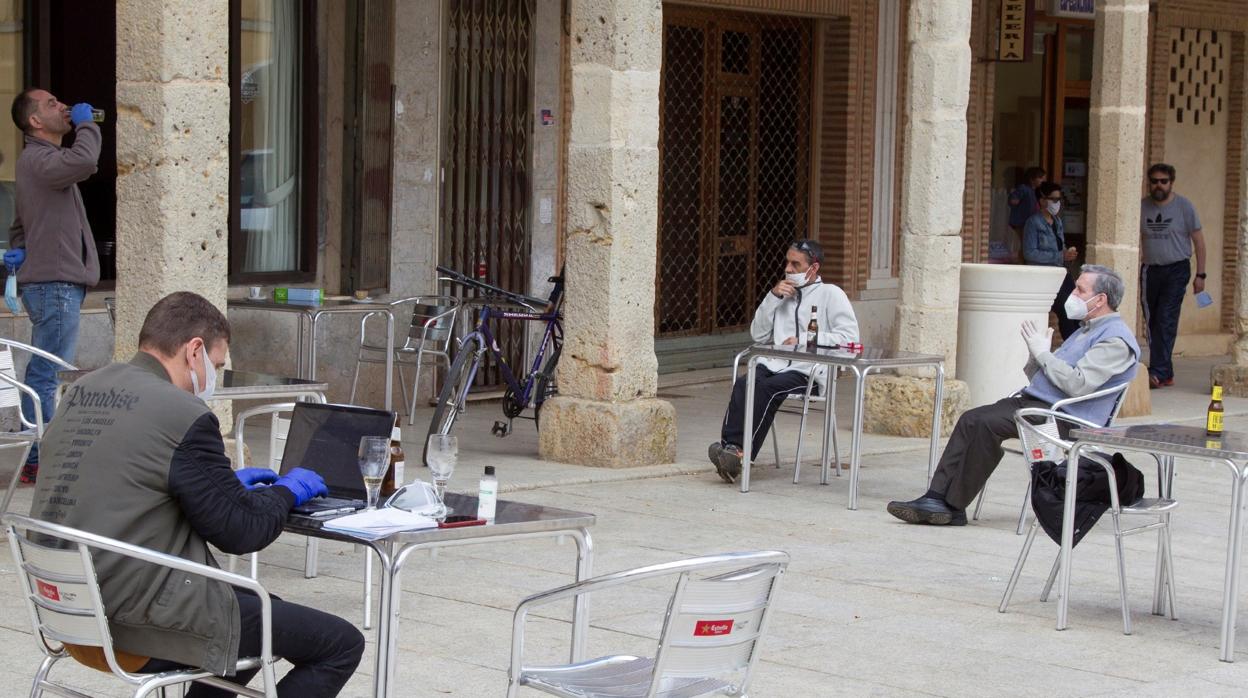 Vecinos de Villalpando, en la terraza de uno de sus bares guardando la distancia de seguridad