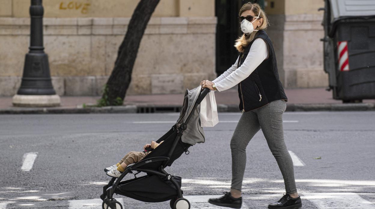 Una mujer pasea con un niño en Valencia durante fase 0 de desecalada