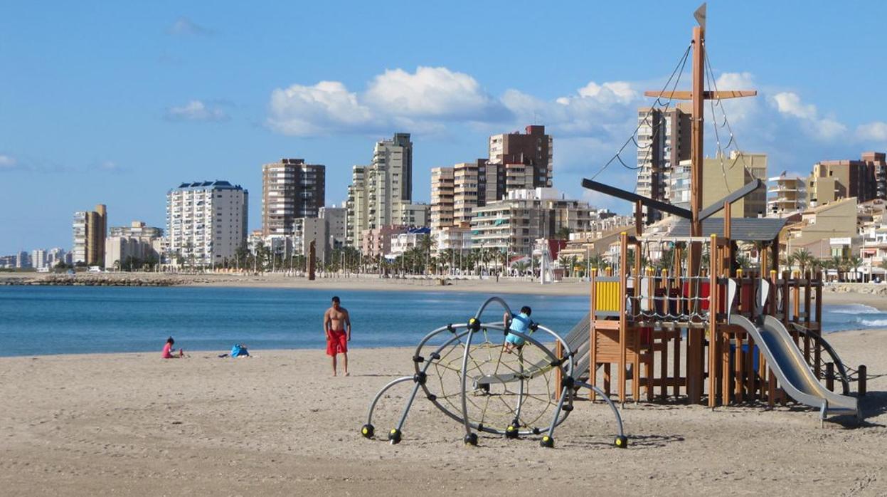 Dos niños con su padre disfrutando de la playa en El Campello