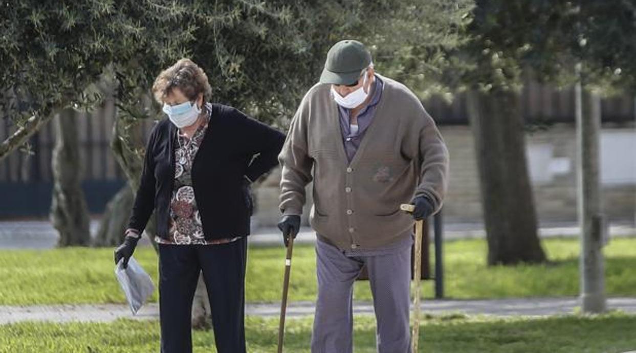 Dos ancianos pasean con mascarillas