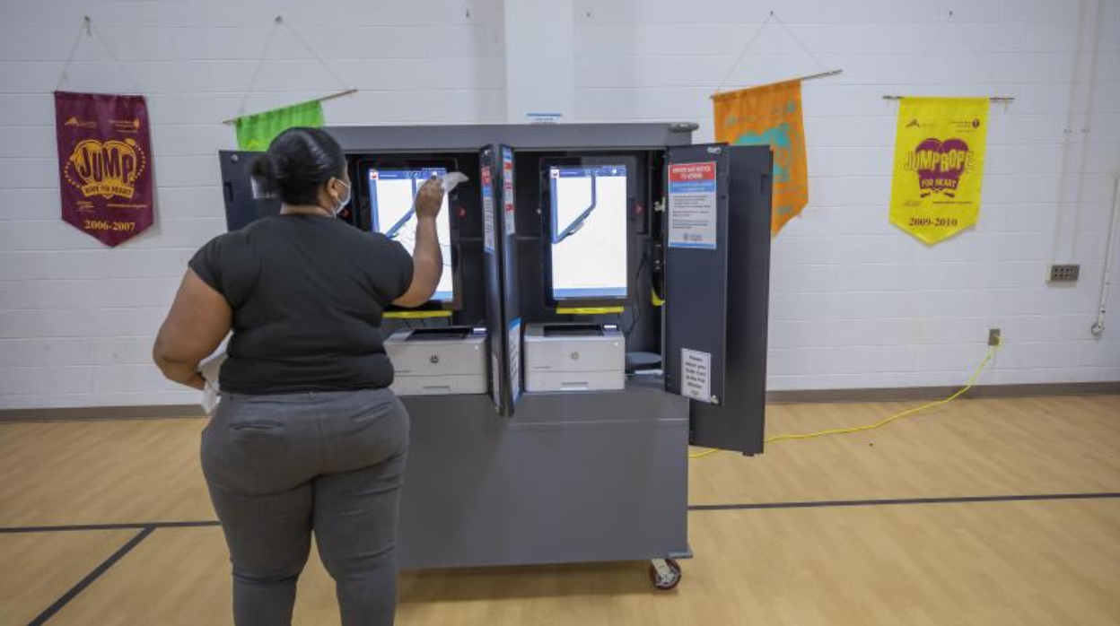 Una empleada limpia las pantallas de unas máquinas de voto electrónico en Georgia (EE.UU.) el lunes