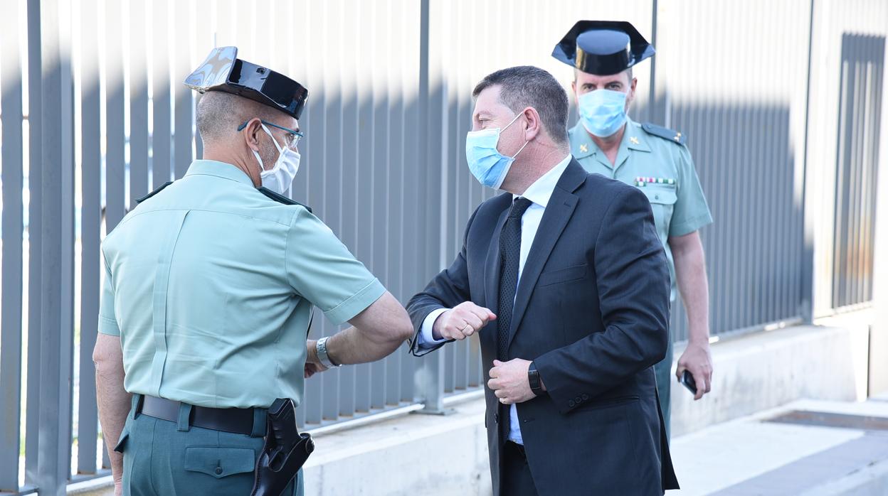 Page saluda con el codo a un miembro de la Guardia Civil en su visita a las instalaciones de Válquer Laboratorios en Villaminaya (Toledo)