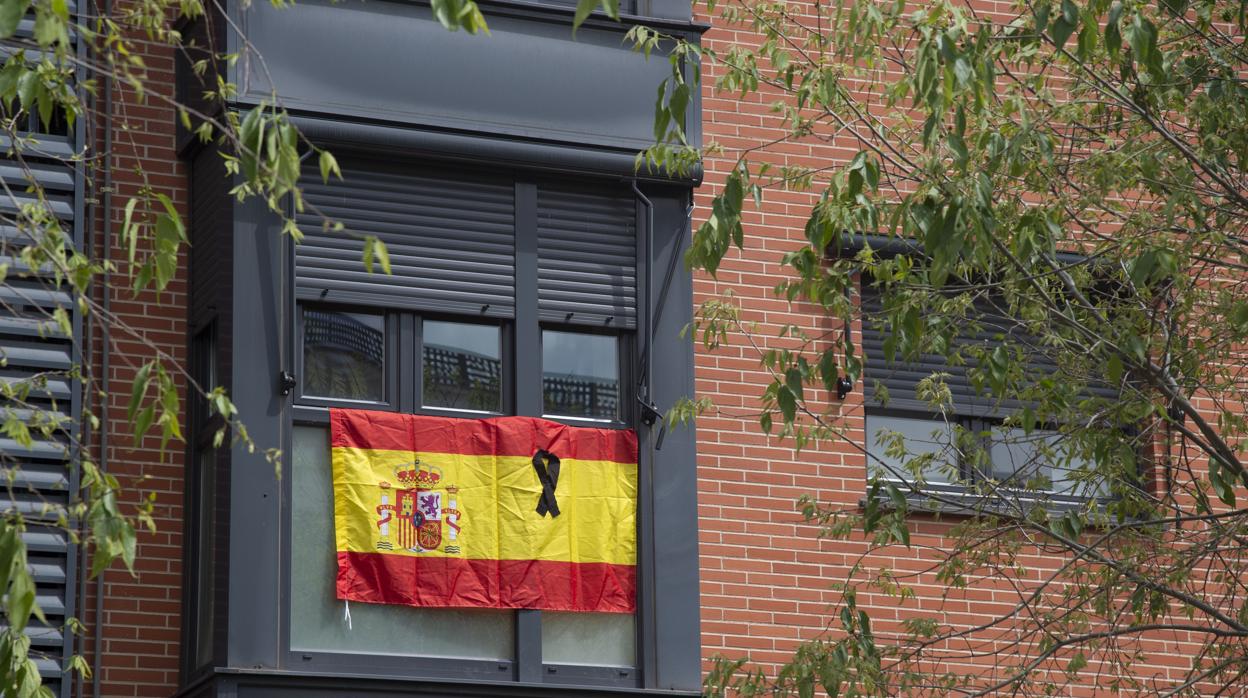 Imagen de una bandera de España con un crespón negro en señal de duelo por las víctimas del coronavirus