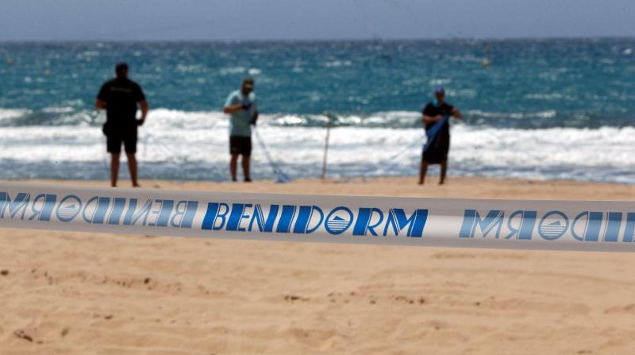 Operarios del Ayuntamiento señalizandno las zonas de uso en la playa de Benidorm