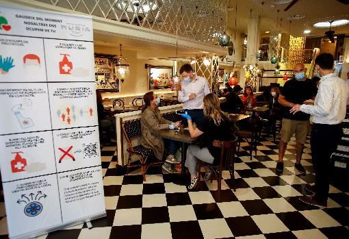 Cartel con medidas de seguridad a las puertas de un restaurante de Barcelona