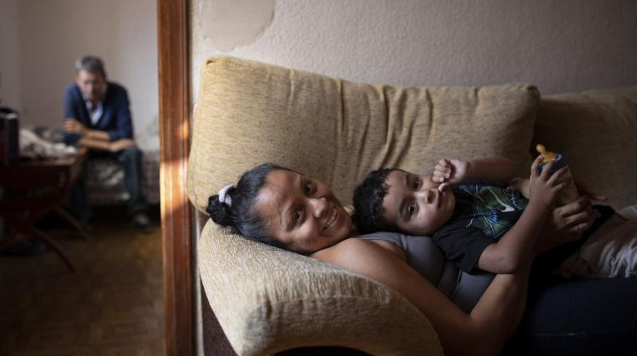 Miguel Ángel Sánchez, al fondo, y su esposa y su hijo, en el sofá de su casa de Pacífico. Son una de las familias que reciben alimentos