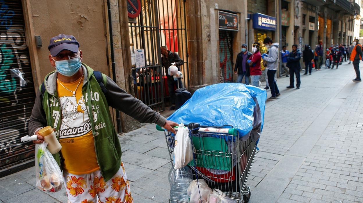 Una persona tras recoger una bolsa de comida en la parroquia de Santa Anna de Barcelona