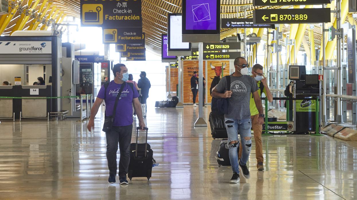 Pasajeros con mascarillas en la T4 de Barajas