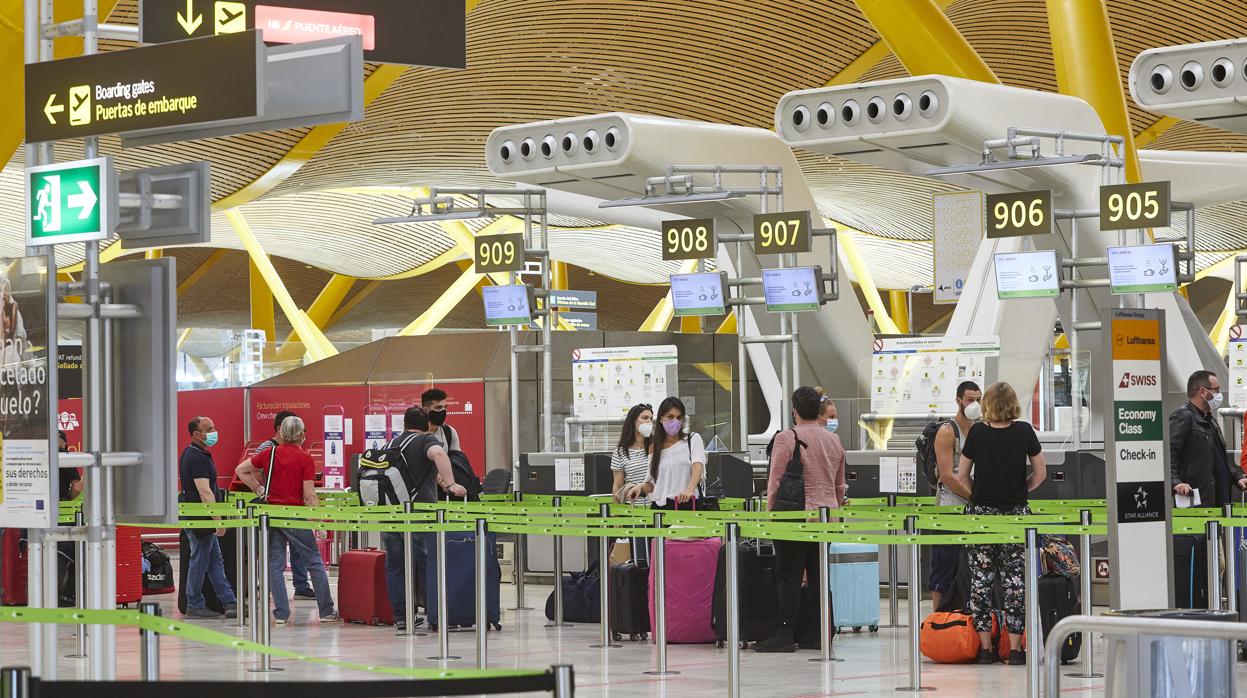 Pasajeros con mascarillas en la T4 de Barajas